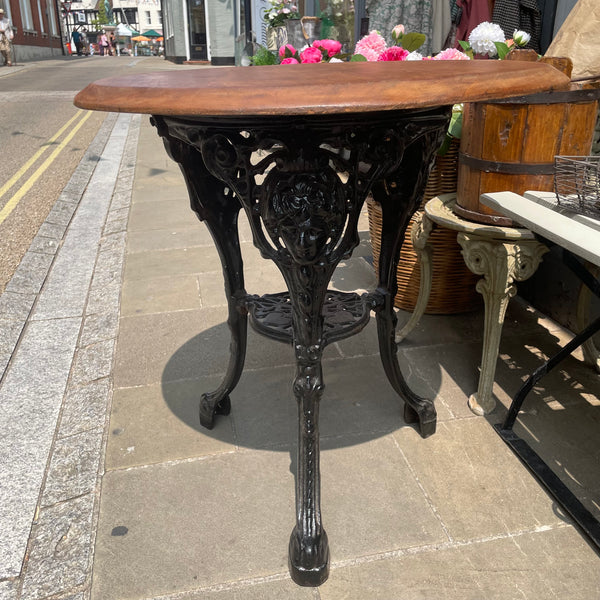 Vintage round garden table with cast iron base. Side view
