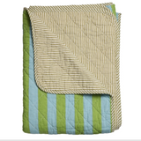 A folded quilted blanket or throw with a striped pattern, shown on a plain white background. The top side has narrow beige and brown stripes, and the underside shows alternating light blue and olive green vertical stripes.