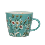 A turquoise ceramic mug decorated with a delicate daisy and wildflower pattern, featuring a matching handle and a white interior, set against a neutral light gray background.