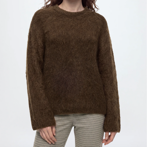 files/A_woman_modeling_a_brown_fuzzy_knit_crewneck_sweater_against_a_plain_light_gray_studio_background..png