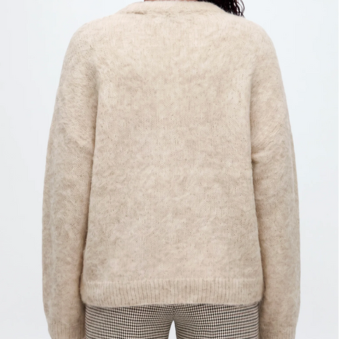 files/A_woman_viewed_from_behind_wearing_a_cream-colored_fuzzy_alpaca_knit_sweater_and_striped_pants_against_a_light_gray_studio_background..png