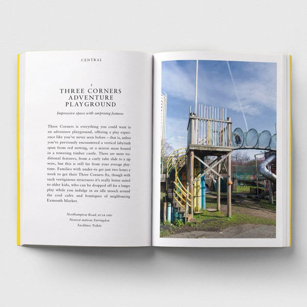 An open printed magazine or booklet laid flat on a light gray background. The left page contains a travel article titled 'Three Corners Adventure Playground' with black text on white paper, and the right page shows a photograph of a wooden playground structure with swings under a blue sky.