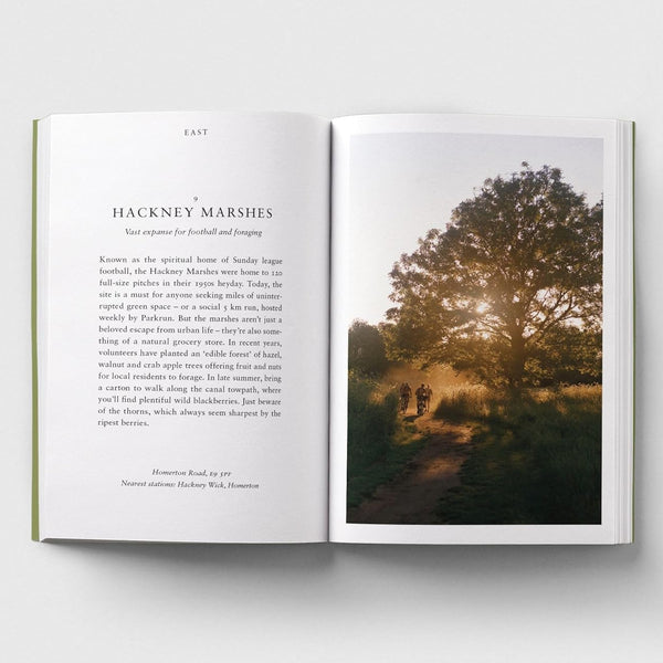 An open hardcover book laid flat on a light gray background, showing a printed page with text on the left and a landscape photograph of Hackney Marshes on the right.