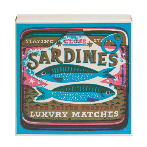 A box of matches with a vintage windmill press design featuring two sardines and the text 'SARDINES STAYING CLOSE MAKE LUXURY MATCHES'.