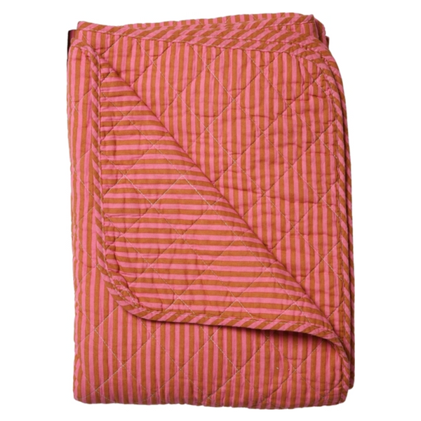 A folded quilted blanket with a vertical stripe pattern in coral pink and white, shown against a plain white background.