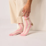Pink and white striped socks with 'AMORE' text worn by a person.