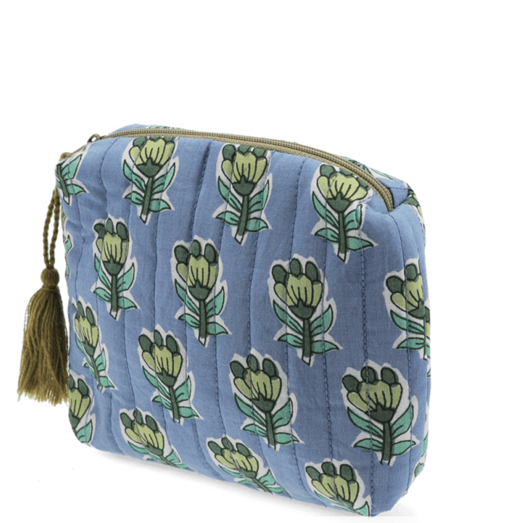 Blue quilted makeup bag with green floral patterns on a white background
