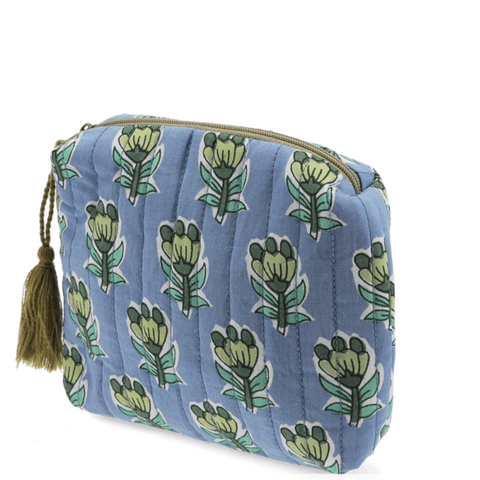 Blue quilted makeup bag with green floral patterns on a white background