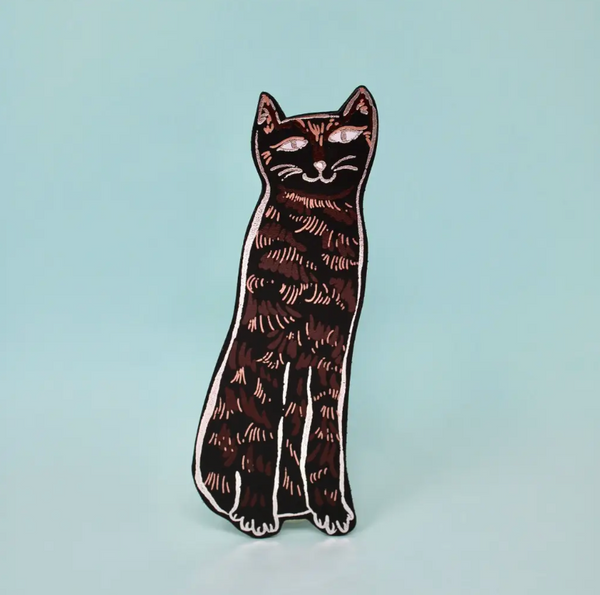 A tall, black leather bookmark in the shape of a cat, with a simple, stylized design.