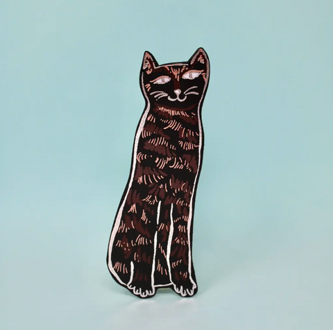 A tall, black leather bookmark in the shape of a cat, with a simple, stylized design.