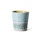 Teal ceramic cup with textured design on a white background