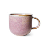 Pink ceramic mug with speckled texture on a white background