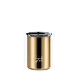 A gold stainless steel travel tumbler with a black lid and a black vertical accent stripe, featuring the 'frank green' logo near the bottom, set against a plain white background.