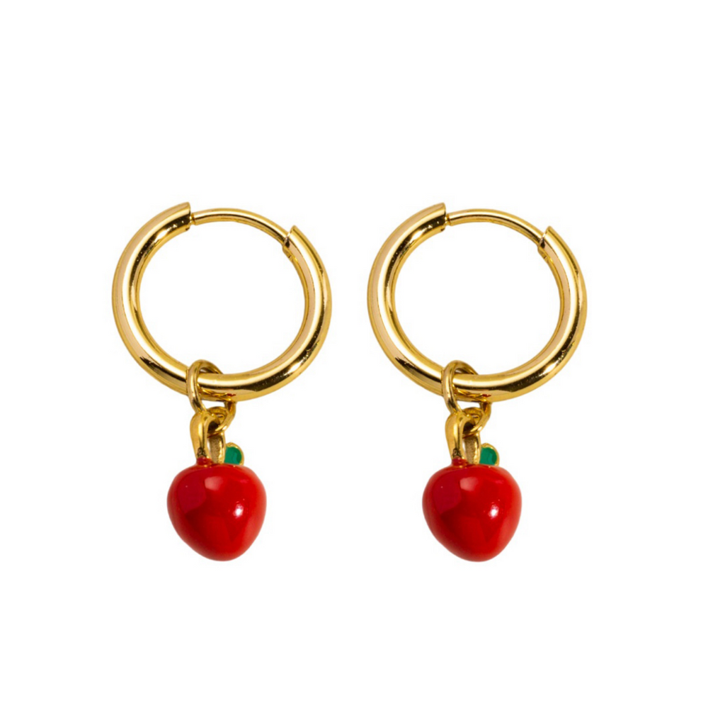 Gold hoop earrings with red apple charms on a white background