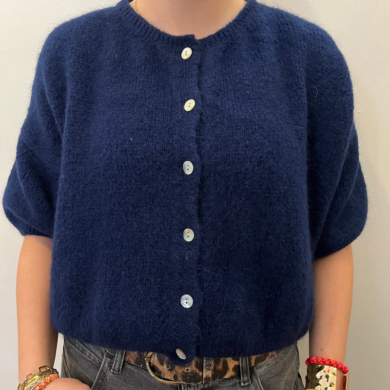 Navy blue cardigan worn by a person on a plain background