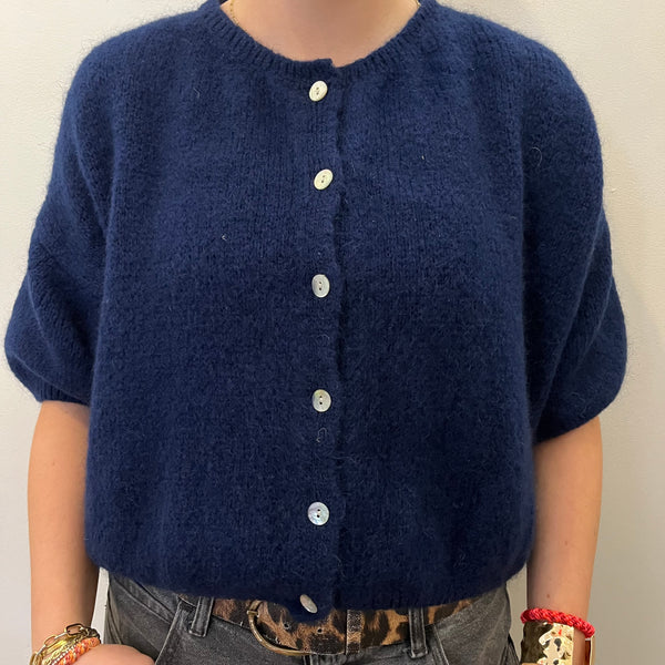 Navy blue cardigan worn by a person on a plain background
