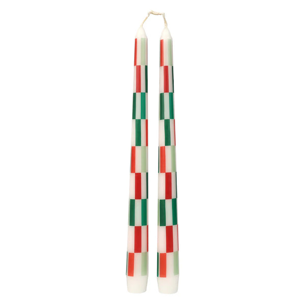 Pair of checkered candles with red, green, and white pattern on a white background