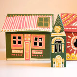Three hand-painted wooden house-shaped ornaments with colorful folk-art patterns, displayed on a light beige background.