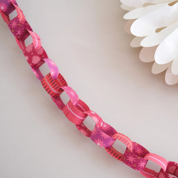 Close-up of a pink floral-patterned ribbon with white flowers in the background.