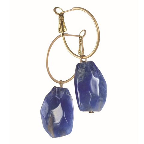 Gold hoop earrings with blue stone drops on a white background