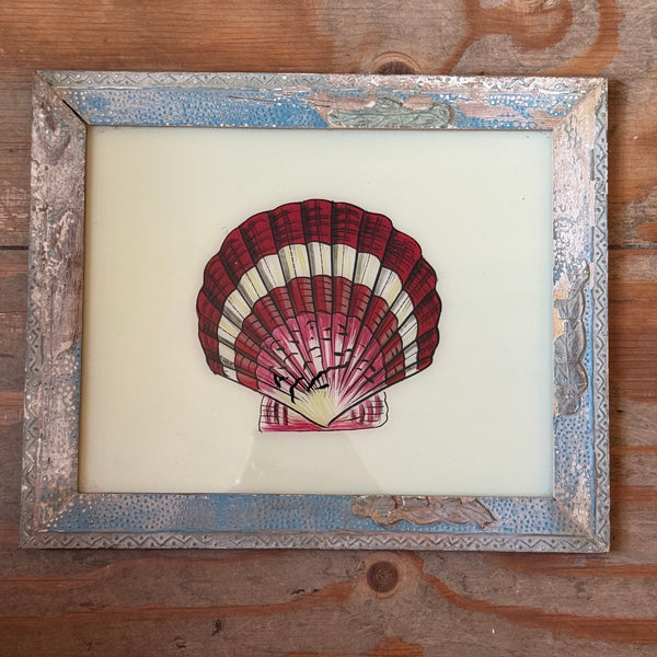 Framed artwork of a red and white shell on a wooden surface