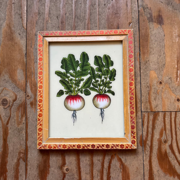 Framed artwork of two radishes on a wooden background
