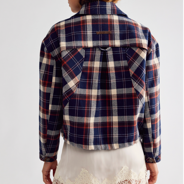 Free People Morant Jacket in Navy A model shown from the back wearing a cropped plaid flannel shirt jacket in navy, red, and cream, 
