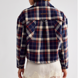 Free People Morant Jacket in Navy A model shown from the back wearing a cropped plaid flannel shirt jacket in navy, red, and cream, 