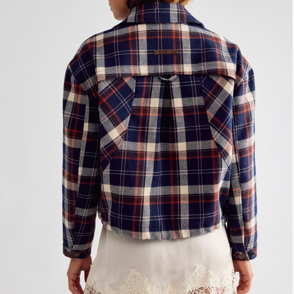 Free People Morant Jacket in Navy A model shown from the back wearing a cropped plaid flannel shirt jacket in navy, red, and cream, 