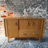 Wooden sideboard against a stone wall
