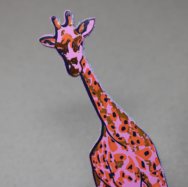 A hot pink and orange giraffe-shaped leather bookmark with spotted patterns.