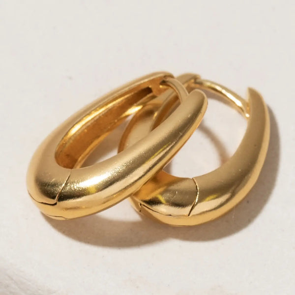 Pair of gold hoop earrings on a light background