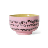 Pink ceramic bowl with black pattern on a white background