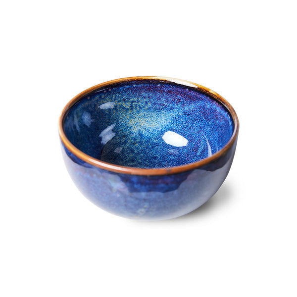 Blue ceramic bowl with a speckled texture on a white background