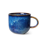 Blue ceramic mug with a speckled texture on a white background