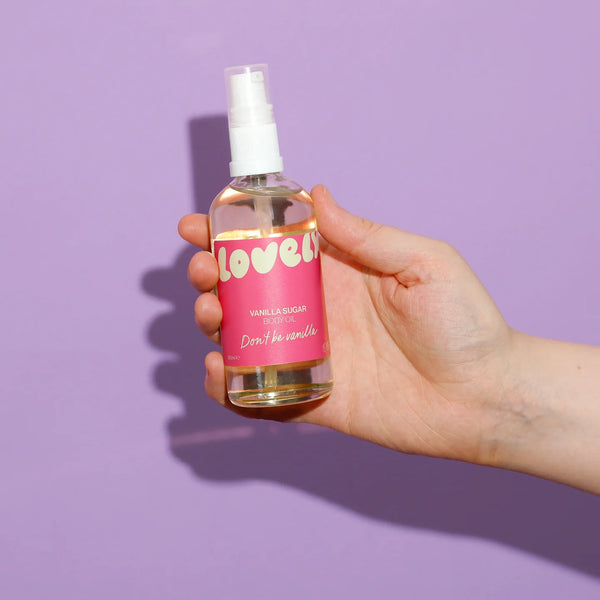 Hand holding a bottle of 'lovelys' vanilla sugar on a purple background