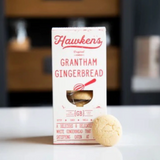 Box of Hawken's Grantham Gingerbread with a gingerbread cookie on a blurred background