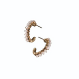 Pair of gold hoop earrings with pearl-like beads on a white background