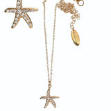 Gold starfish necklace with a pendant on a white background
