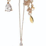 gold necklace with teardrop-shaped diamond pendants on a white background