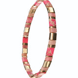 Bracelet with pink and gold beads on a white background