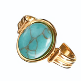Gold ring with a turquoise stone on a white background