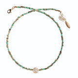 Necklace with turquoise beads and a pink pearl on a white background