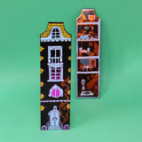 Two decorative magnets with house designs on a green background