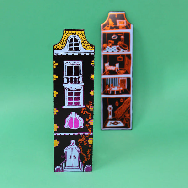 Two decorative magnets with house designs on a green background