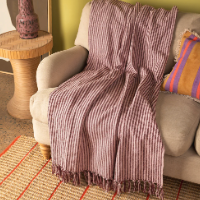 Ian Snow Plum & Dusty Rose Recycled Cotton Striped Throw on sofa