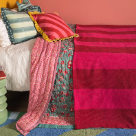Ian Snow Red & Pink Recycled Cotton Wide Stripe Throw on bed