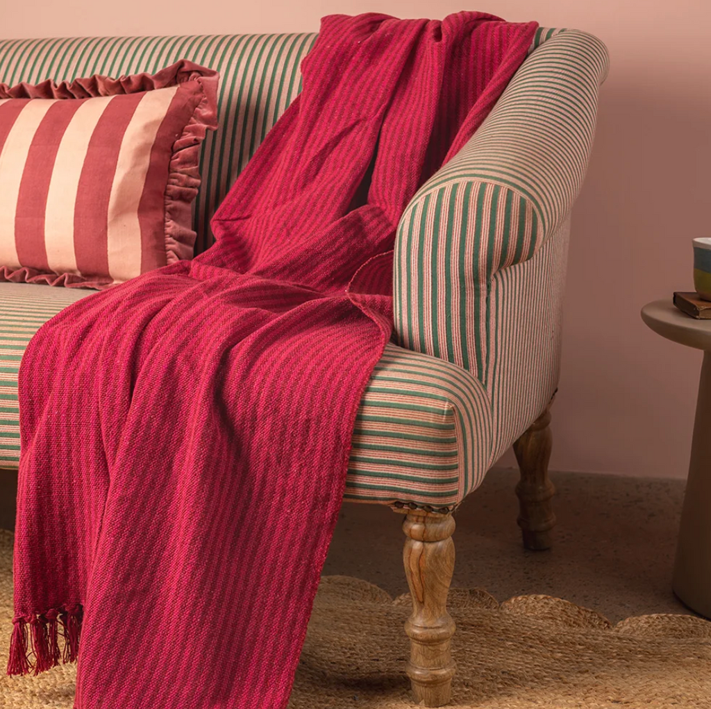 Ian Snow Red and Pink Recycled Cotton Striped Throw on sofa