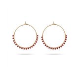 A pair of gold hoop earrings with small red bead accents along the lower curve, displayed against a clean white background.