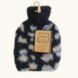Jess & Lou A plush faux-fur hot water bottle with an animal print pattern in black, beige, and gray, hanging from a wooden hanger with a paper brand tag that reads 'Jess & Lou'.